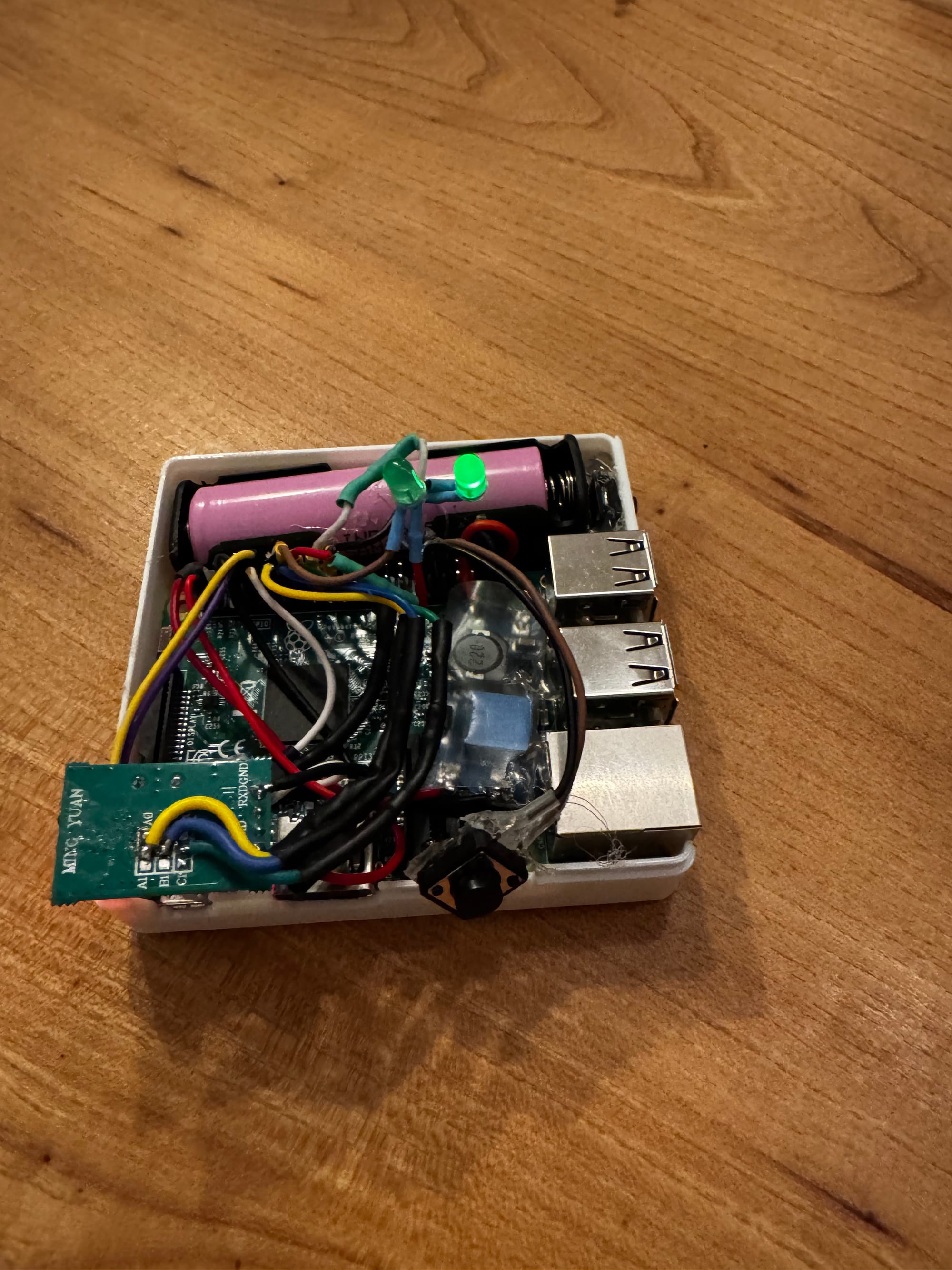 The inside of RetroModem, showing the Raspberry Pi, battery, wiring and infrared adapter board